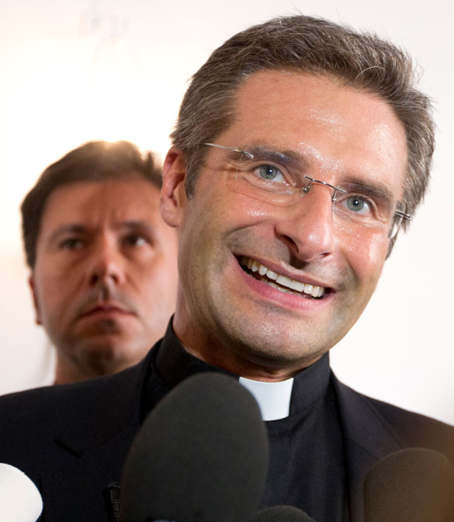 Katolska prästen Krzystof Charamsa med sin pojkvän i bakgrunden. Foto: AP